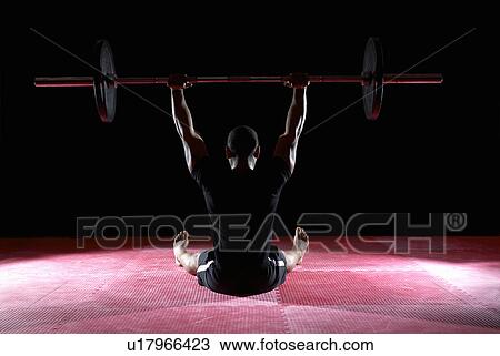 man lifting weight bar whilst sitting View Large Photo Image Stock Image - man lifting weight bar whilst sitting. Fotosearch