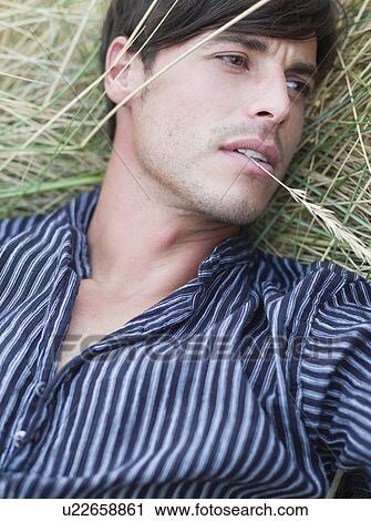 man lying in grass relaxing View Large Photo Image Stock Image - man lying in grass relaxing. Fotosearch