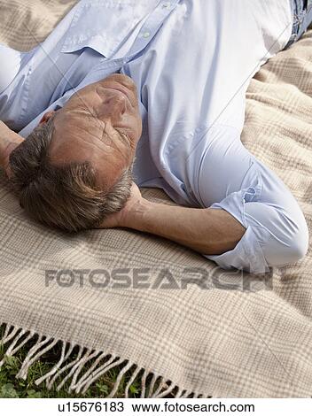 Man lying relaxed on a blanket View Large Photo Image Stock Image - Man lying relaxed on a blanket. Fotosearch