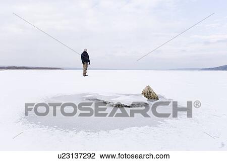 Stock Image - Man on frozen lake. Fotosearch
