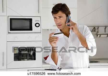 Man on phone with credit card View Large Photo Image Stock Photograph - Man on phone with credit card. Fotosearch