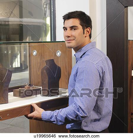 Stock Photograph - man opening/closing display cabinet. Fotosearch