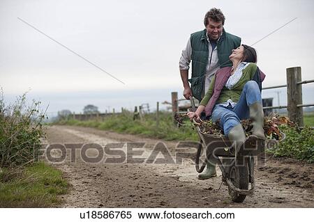 man pushing woman in wheelbarrow View Large Photo Image Stock Photography - man pushing woman in wheelbarrow. Fotosearch