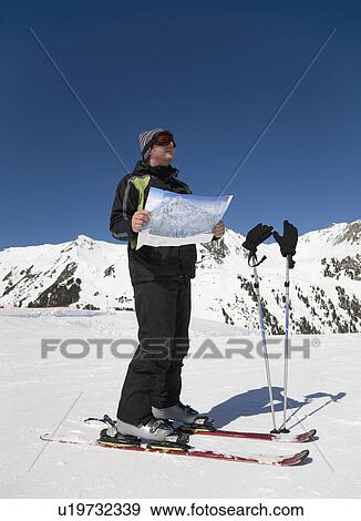 Stock Photo - Man reading map on ski slope. Fotosearch