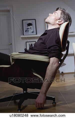 man relaxing in chair View Large Photo Image Stock Photo - man relaxing in chair. Fotosearch