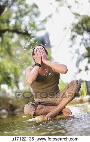 Stock Photography - Man sitting in a river. Fotosearch