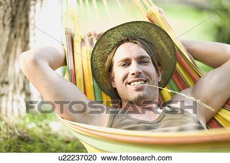 Stock Image - Man sleeping in a hammock. Fotosearch
