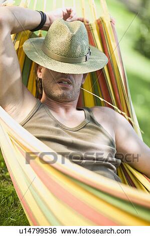 Stock Photograph - Man sleeping in a hammock. Fotosearch
