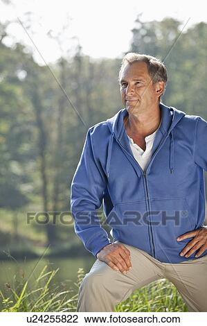 Man stretching beside lake View Large Photo Image Stock Image - Man stretching beside lake. Fotosearch