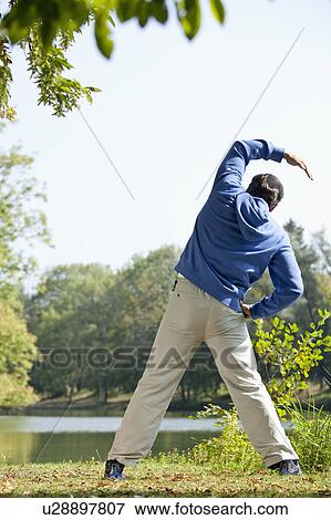 Man stretching beside lake View Large Photo Image Stock Photo - Man stretching beside lake. Fotosearch