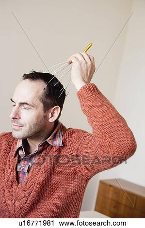 Stock Image - man using scalp massage instrument. Fotosearch