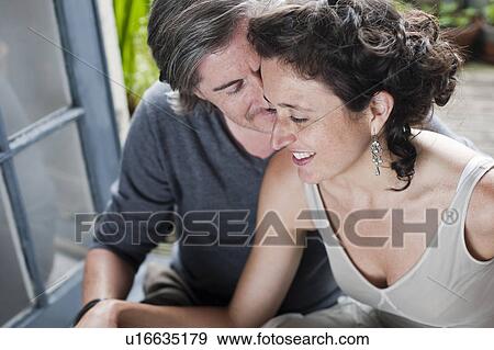 Stock Photo - man whispering in woman ear. Fotosearch