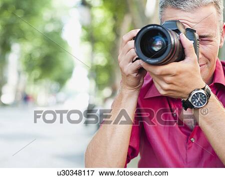 Stock Photo - man with camera taking picture. Fotosearch