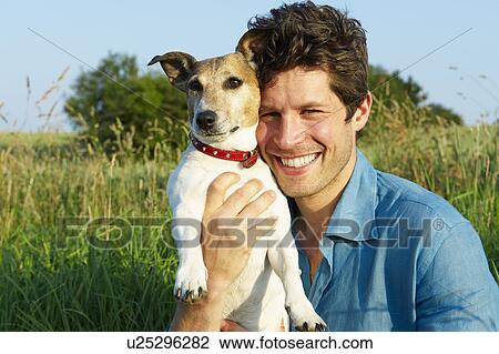 Stock Image - Man with dog, in a wheat field. Fotosearch