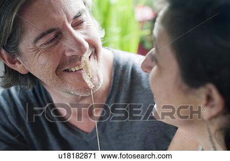 Stock Image - man & woman playing with grass stalk. Fotosearch