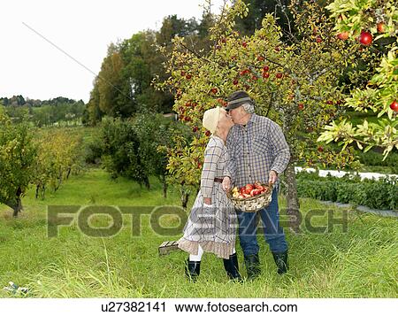 Mature couple kissing in garden View Large Photo Image Stock Image - Mature couple kissing in garden. Fotosearch
