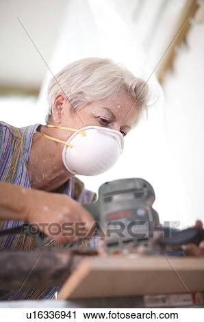 Stock Image - Mature woman doing DIY. Fotosearch