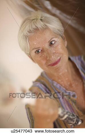 Stock Image - Mature woman doing DIY. Fotosearch