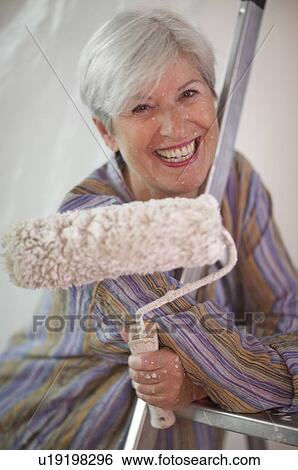 Stock Photograph - Mature woman doing DIY. Fotosearch