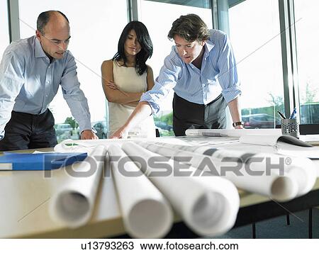 Men and woman looking at blue prints View Large Photo Image Stock Image - Men and woman looking at blue prints. Fotosearch