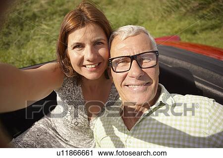 Mid-aged Couple in car self-portrait View Large Photo Image Stock Image - Mid-aged Couple in car self-portrait. Fotosearch