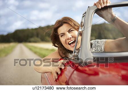 Mid aged woman in sports car View Large Photo Image Stock Image - Mid aged woman in sports car. Fotosearch