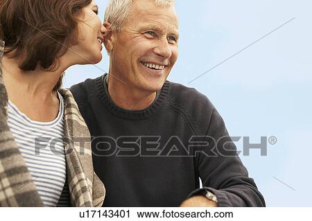 mid-aged woman whispering to man View Large Photo Image Stock Image - mid-aged woman whispering to man. Fotosearch