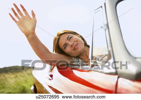 Stock Photography - mid-aged woman's hand out of car window. Fotosearch