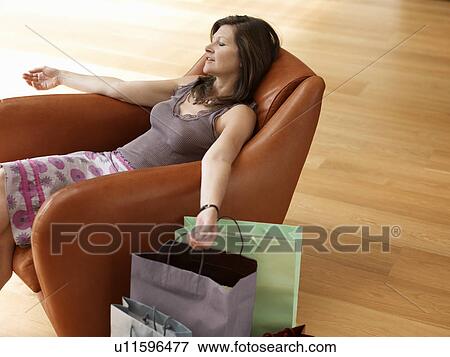 middle-age woman in chair with shopping View Large Photo Image Stock Photo - middle-age woman in chair with shopping. Fotosearch