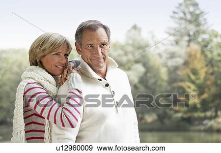 Stock Photo - Middle aged couple at a lake. Fotosearch