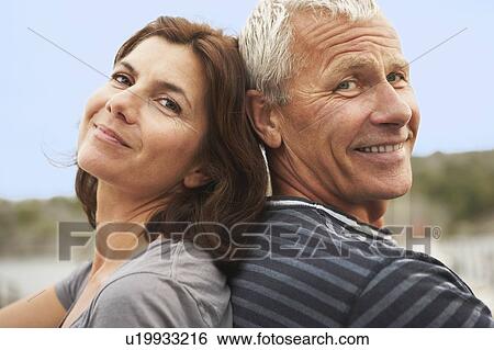Middle aged couple, back to back, smiles View Large Photo Image Stock Photograph - Middle aged couple, back to back, smiles. Fotosearch