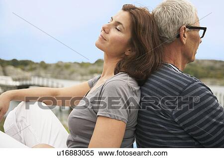 Stock Photography - Middle aged couple, back to back. Fotosearch