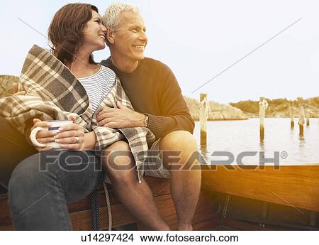 Middle aged couple cuddling on old boat View Large Photo Image Picture - Middle aged couple cuddling on old boat. Fotosearch