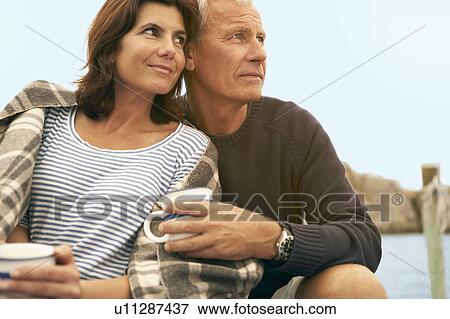 Middle aged couple cuddling together View Large Photo Image Stock Photo - Middle aged couple cuddling together. Fotosearch