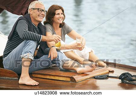 Middle aged couple drinking on boat View Large Photo Image Stock Photo - Middle aged couple drinking on boat. Fotosearch