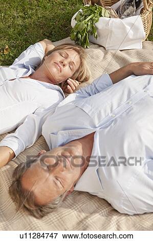 Stock Photo - Middle aged couple on a picnic blanket. Fotosearch