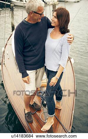 Picture - Middle aged couple on an old boat. Fotosearch