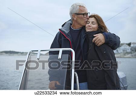 Picture - Middle aged couple on motor boat. Fotosearch