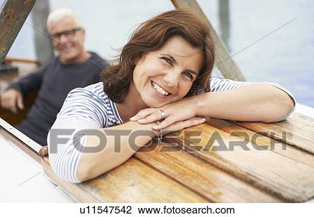 Stock Image - Middle aged couple on old boat. Fotosearch