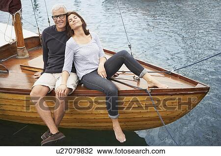 Stock Image - Middle aged couple on old boat. Fotosearch