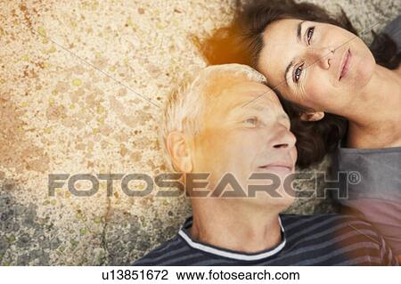 Middle aged couple on rocks with flare View Large Photo Image Stock Image - Middle aged couple on rocks with flare. Fotosearch