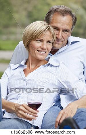Stock Photo - Middle aged couple sitting close. Fotosearch