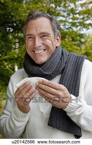 Stock Photograph - Middle aged man with scarf and tissue. Fotosearch