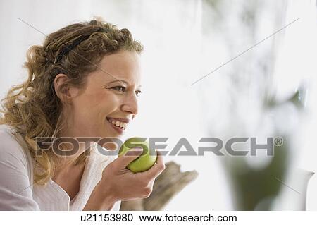 middle-aged woman eating a apple View Large Photo Image Stock Image - middle-aged woman eating a apple. Fotosearch