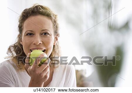 middle-aged woman eating a apple View Large Photo Image Stock Photo - middle-aged woman eating a apple. Fotosearch