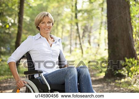 Stock Photograph - Middle aged woman in a wheelchair. Fotosearch