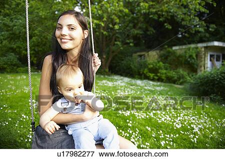 Stock Photo - Mother and baby boy on the swing. Fotosearch