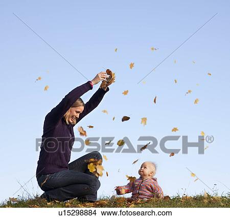 mother and baby throwing autumn leaves View Large Photo Image Picture - mother and baby throwing autumn leaves. Fotosearch