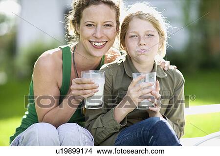 Picture - mother and daughter drinking milk. Fotosearch
