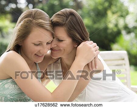 Stock Image - mother and daughter hug in garden. Fotosearch